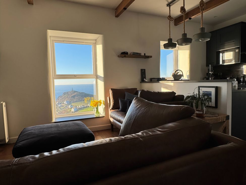 A living room with a window overlooking the sea at Cape View Cape Cornwall near St Just