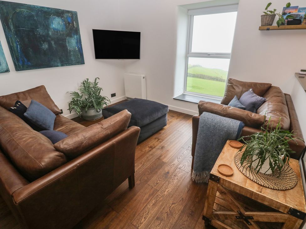 A living room with a sofa and footstool at Cape View Cape Cornwall near St Just