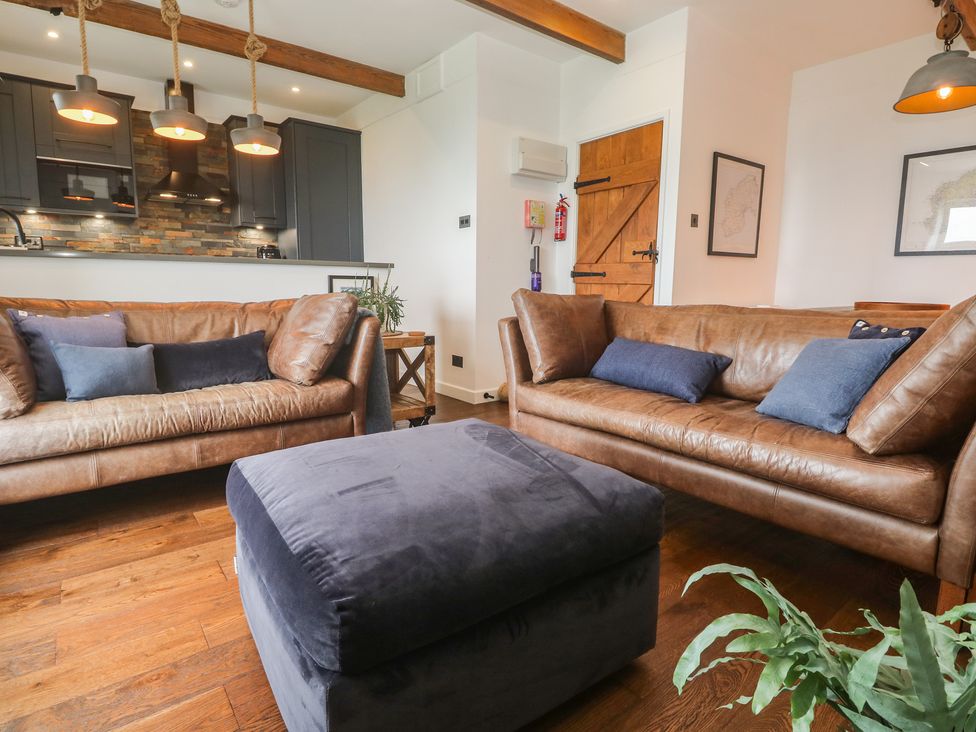 A living room with a sofa and ottoman at Cape View near St Just
