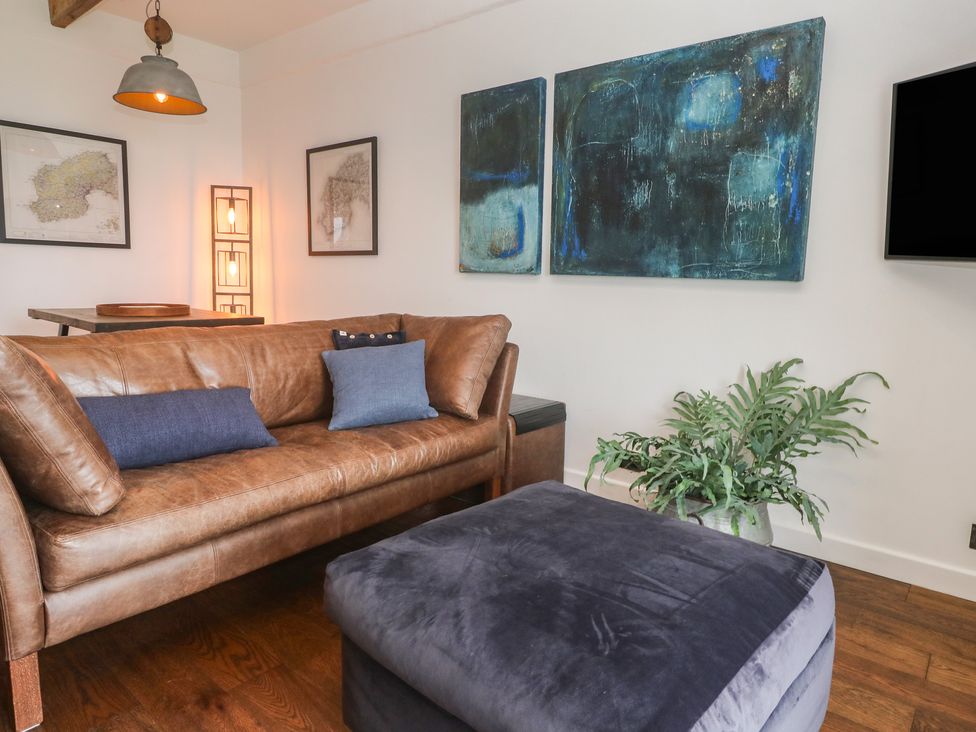A living room with a sofa and artwork at Cape View near St Just