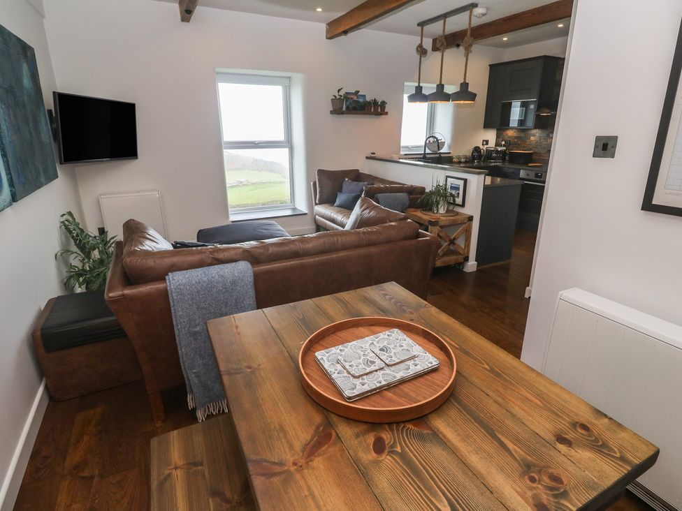 A living room with a sofa and dining table at Cape View Cape Cornwall near St Just