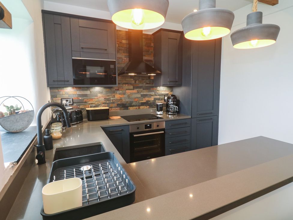 A kitchen with cabinets and appliances at Cape View near St Just