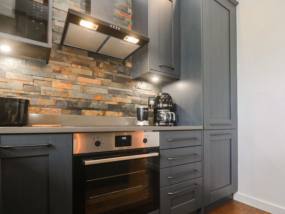 A kitchen with cabinets and appliances at Cape View near St Just