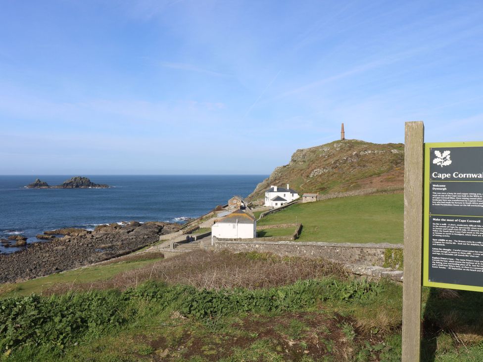 A coastal view with buildings and a sign at Cape View in Cape Cornwall near St Just