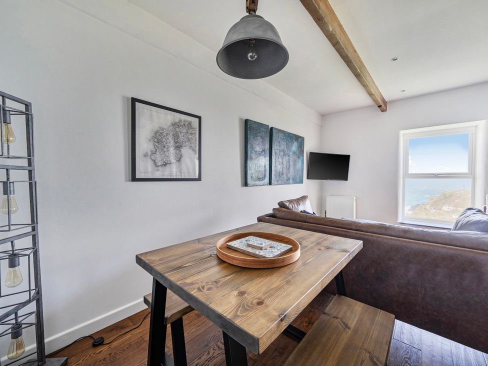 A living room with a table and sofa at Cape View near St Just