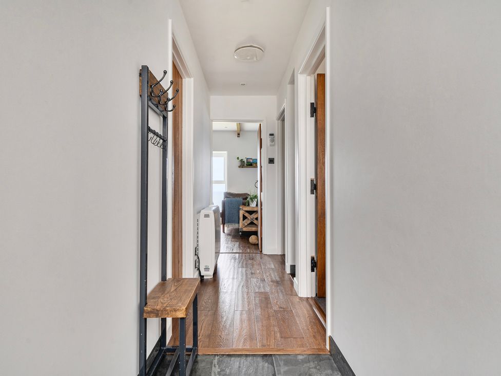 A hallway with a bench and coat rack at Cape View Cape Cornwall near St Just