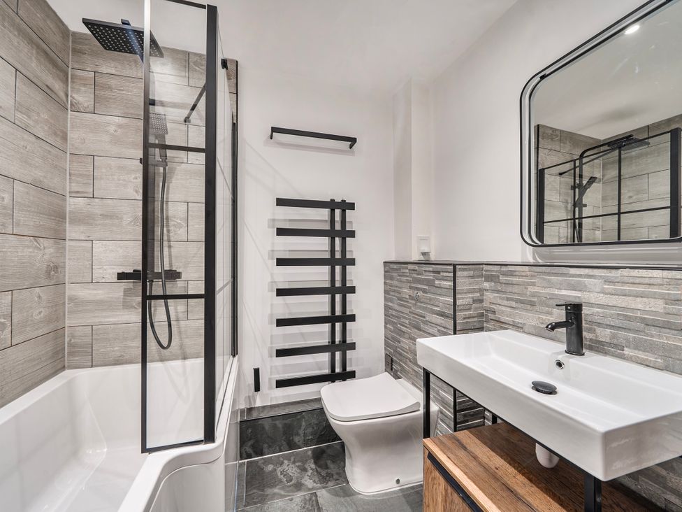 A bathroom with a shower, bathtub, toilet, and sink at Cape View near St Just