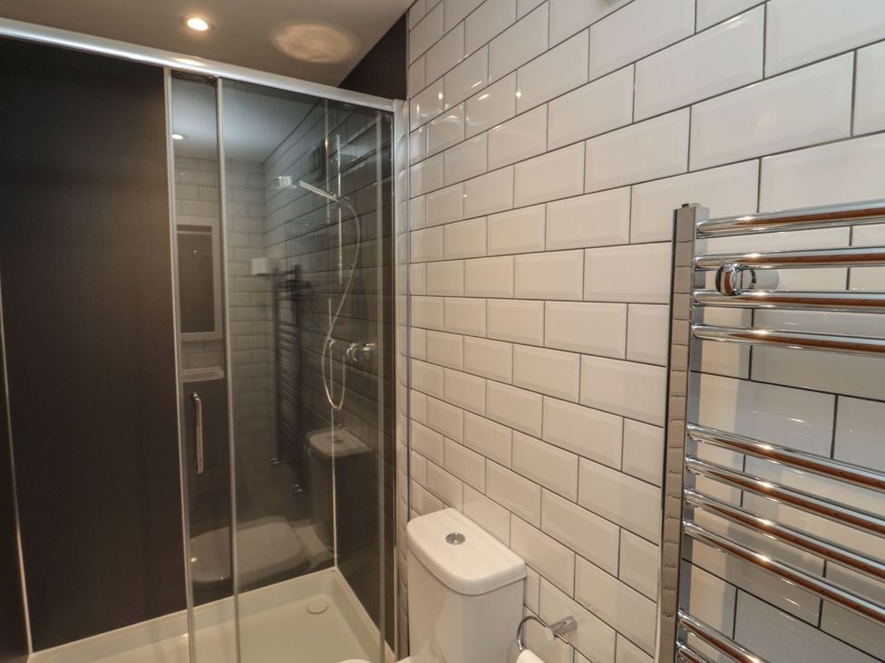 A bathroom with a shower enclosure and toilet at 7 Longstone Close in Chathill