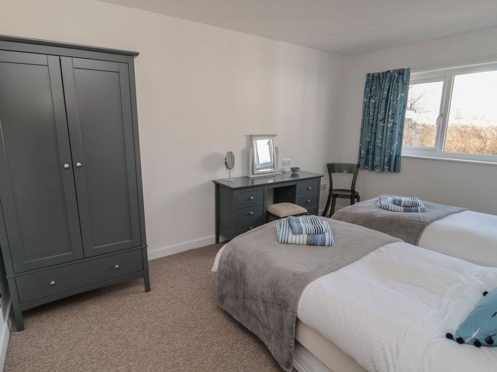 A bedroom with two beds and a desk at 7 Longstone Close in Chathill