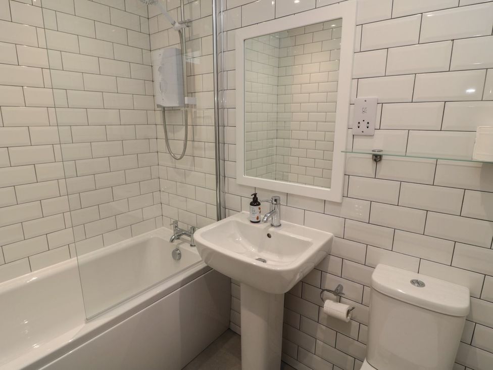 A bathroom with a bathtub, sink, and toilet at 7 Longstone Close Chathill