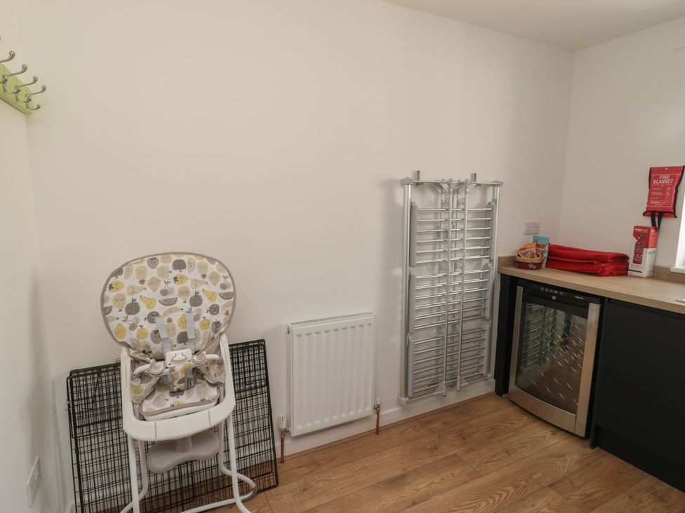 A kitchen with a high chair and wine cooler at 7 Longstone Close Chathill