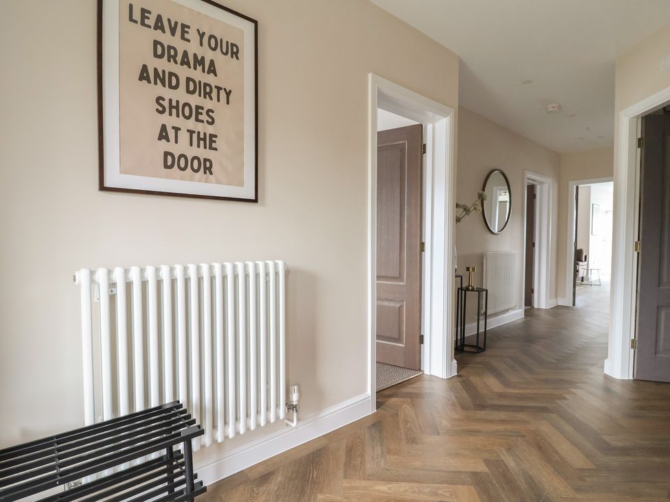 A hallway with a framed poster and mirror at Bella Vista in Deganwy