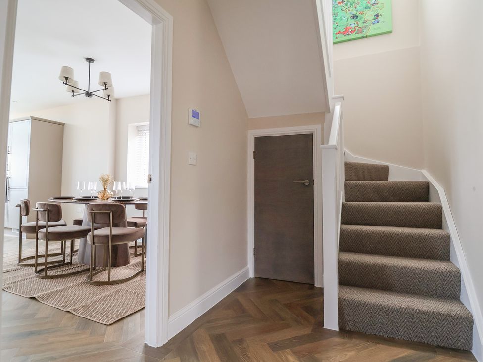 A hallway with a staircase and a view into the dining area at Bella Vista in Deganwy