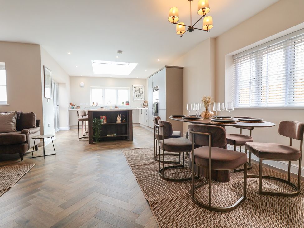 A kitchen with a dining area and sofa at Bella Vista Deganwy