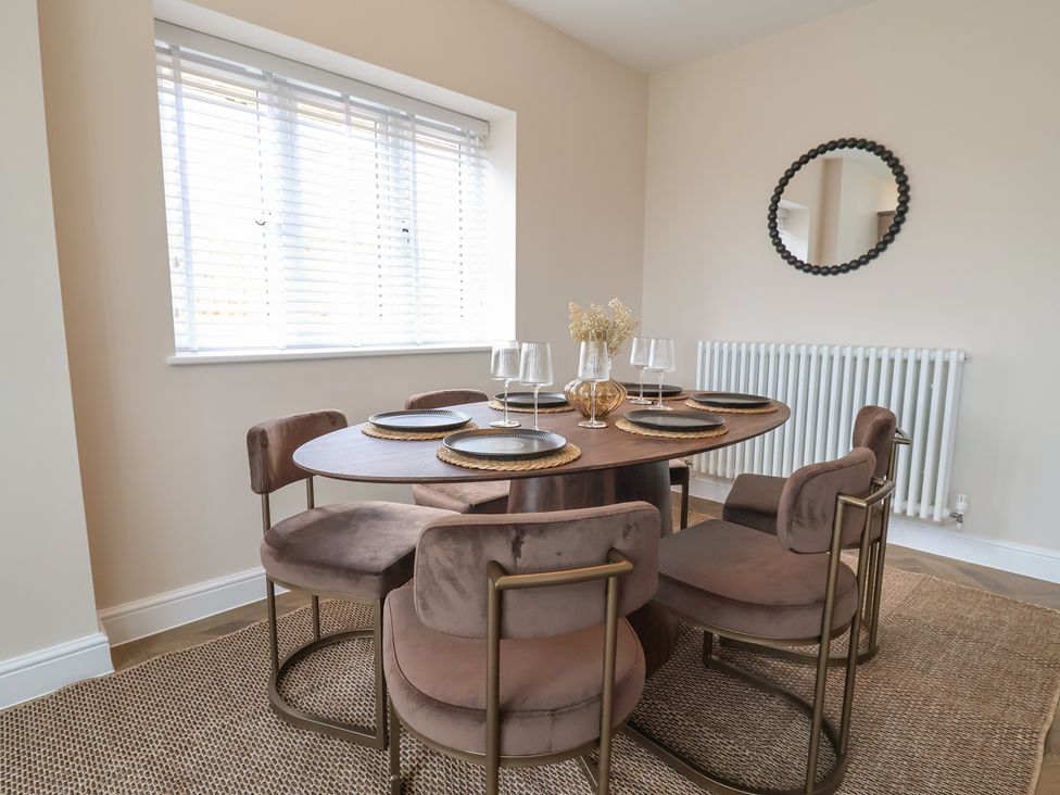 A dining room with a round table and chairs at Bella Vista in Deganwy