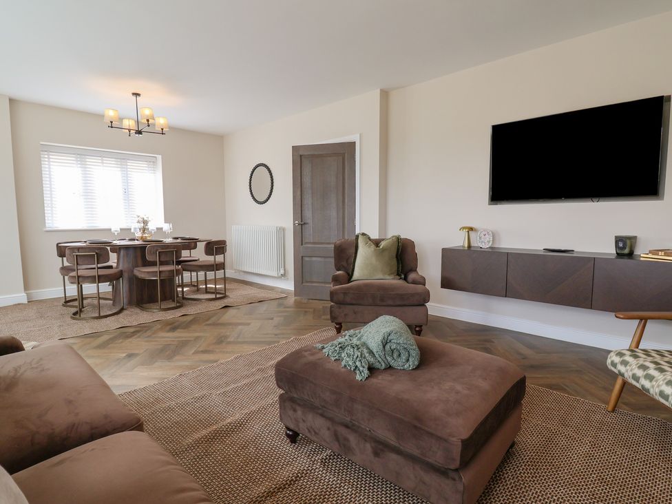 A living room with a dining area and television at Bella Vista in Deganwy