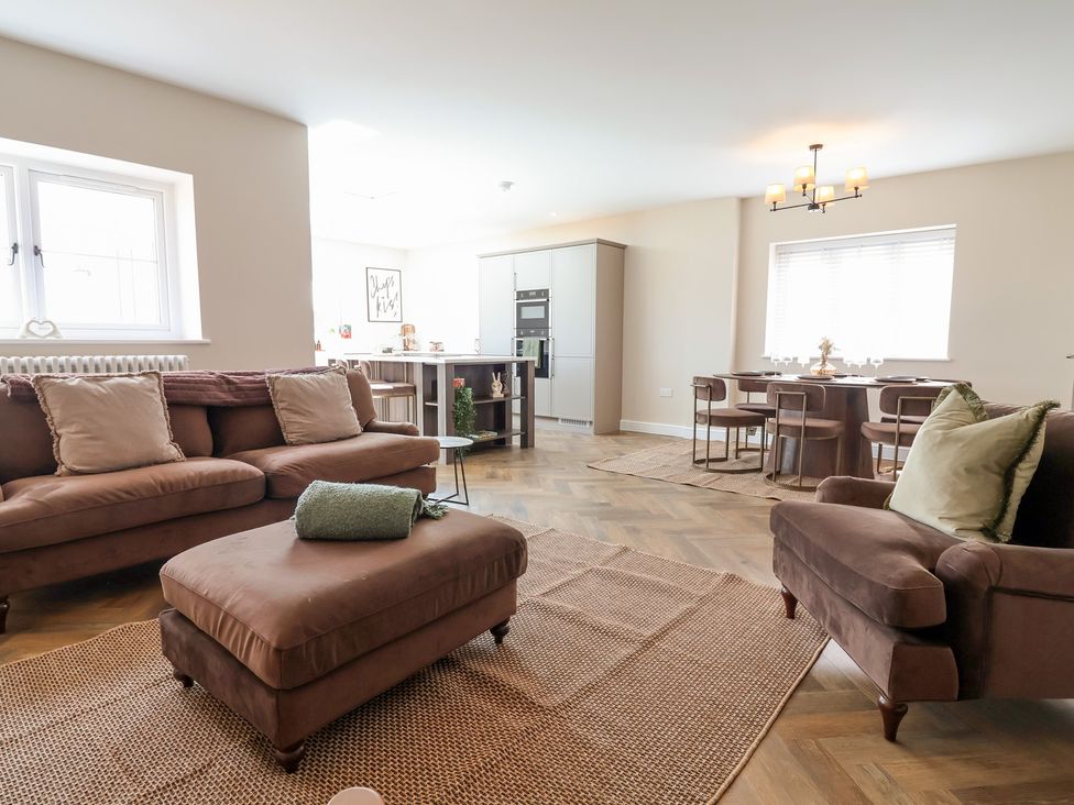 A living room with a sofa and dining area at Bella Vista in Deganwy