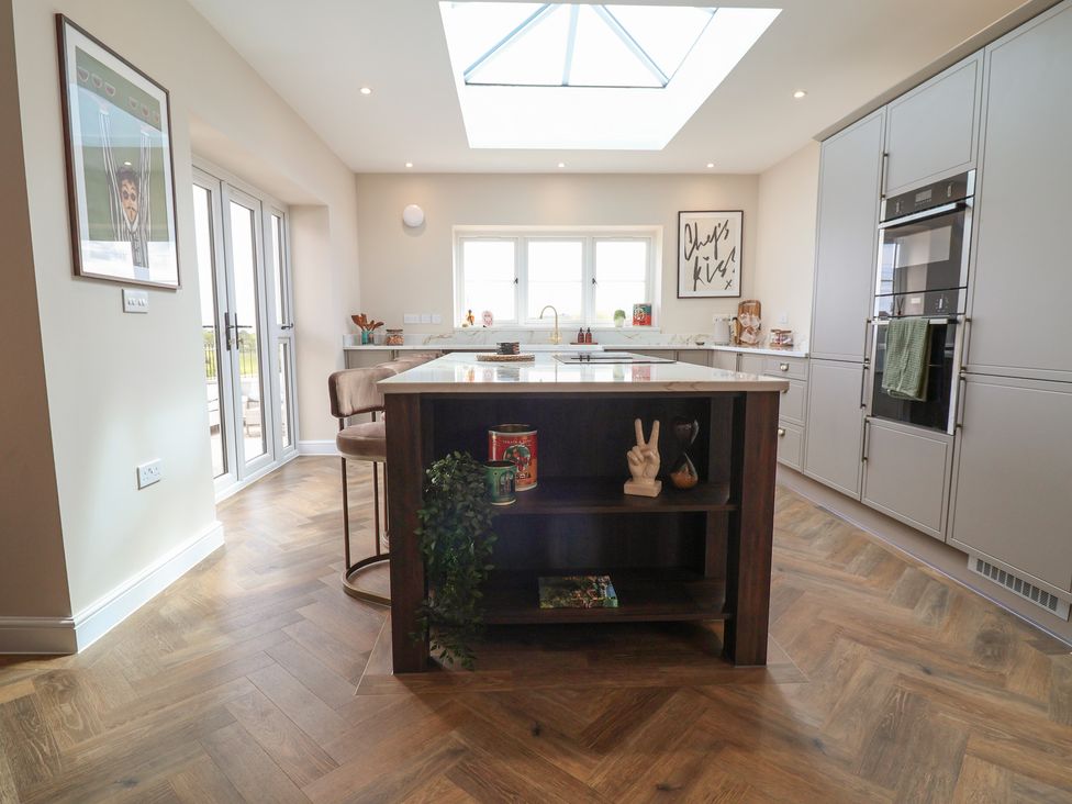 A kitchen with a central island and modern appliances at Bella Vista in Deganwy