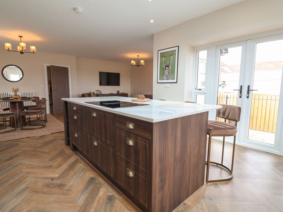 A kitchen with a central island and seating at Bella Vista in Deganwy