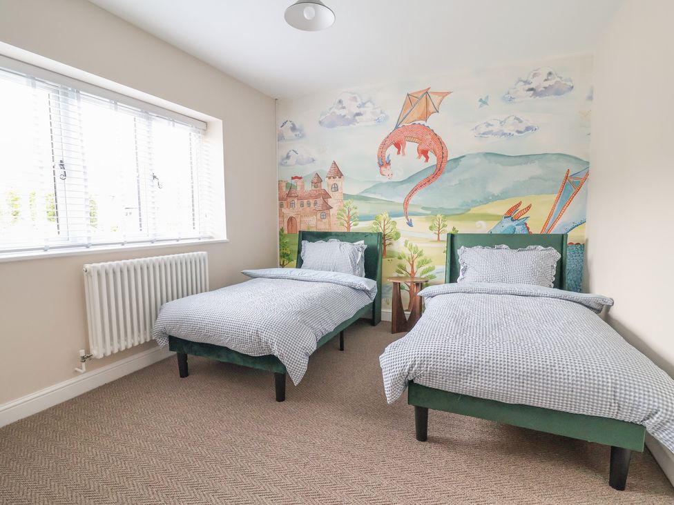 A bedroom with twin beds and a mural at Bella Vista in Deganwy