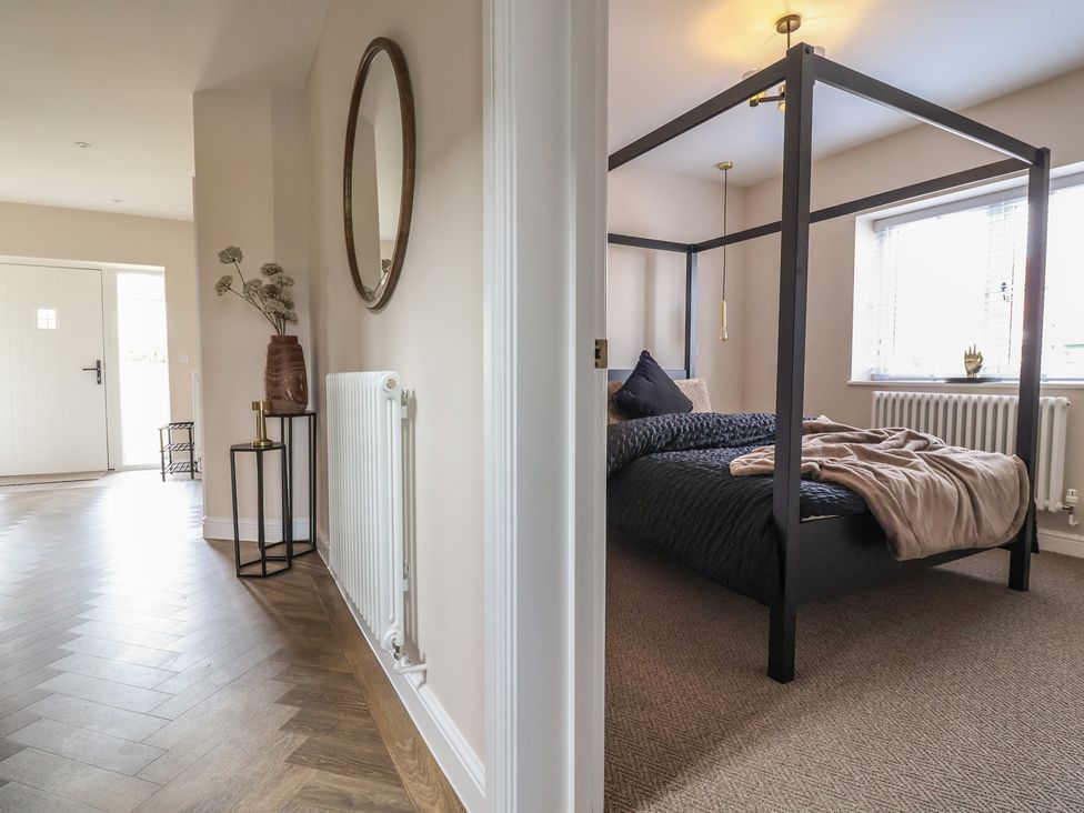 A bedroom with a bed and mirror at Bella Vista in Deganwy