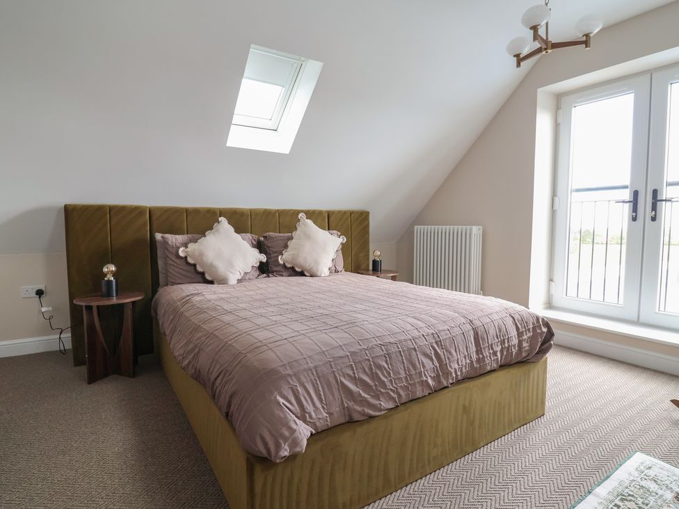 A bedroom with a bed and nightstand at Bella Vista Deganwy