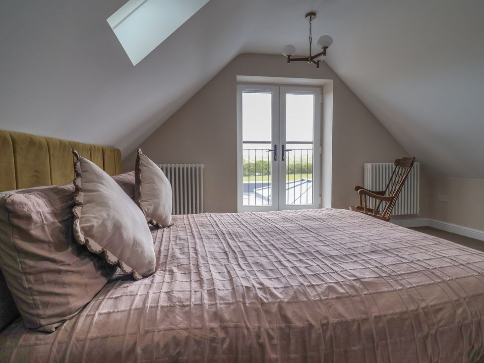 A bedroom with a bed and windows at Bella Vista in Deganwy