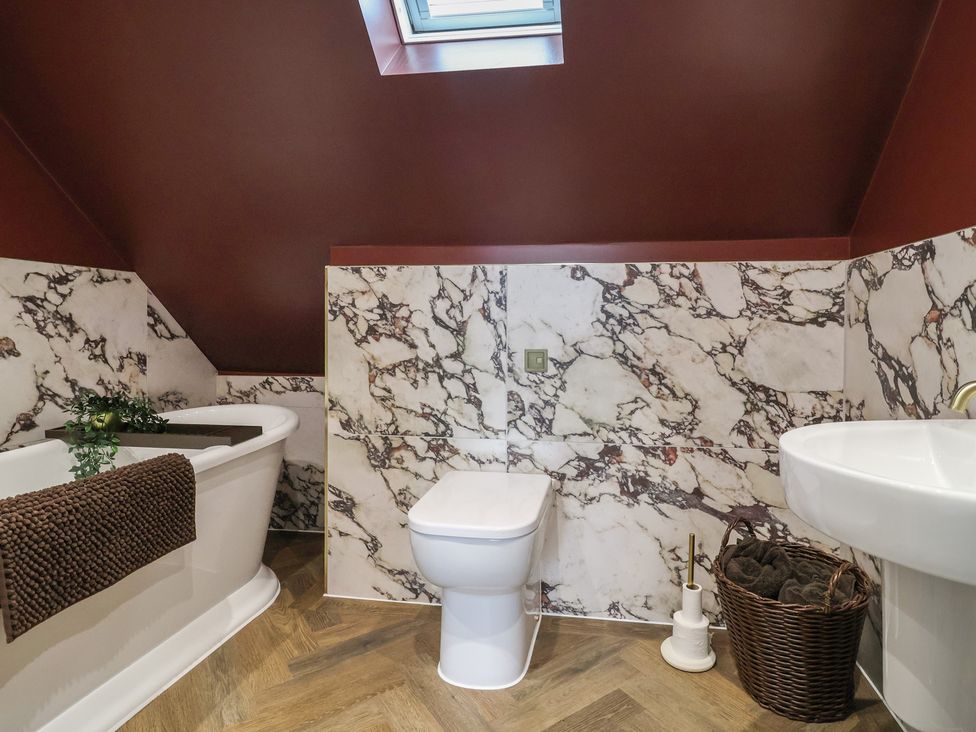 A bathroom with a bathtub and sink at Bella Vista in Deganwy