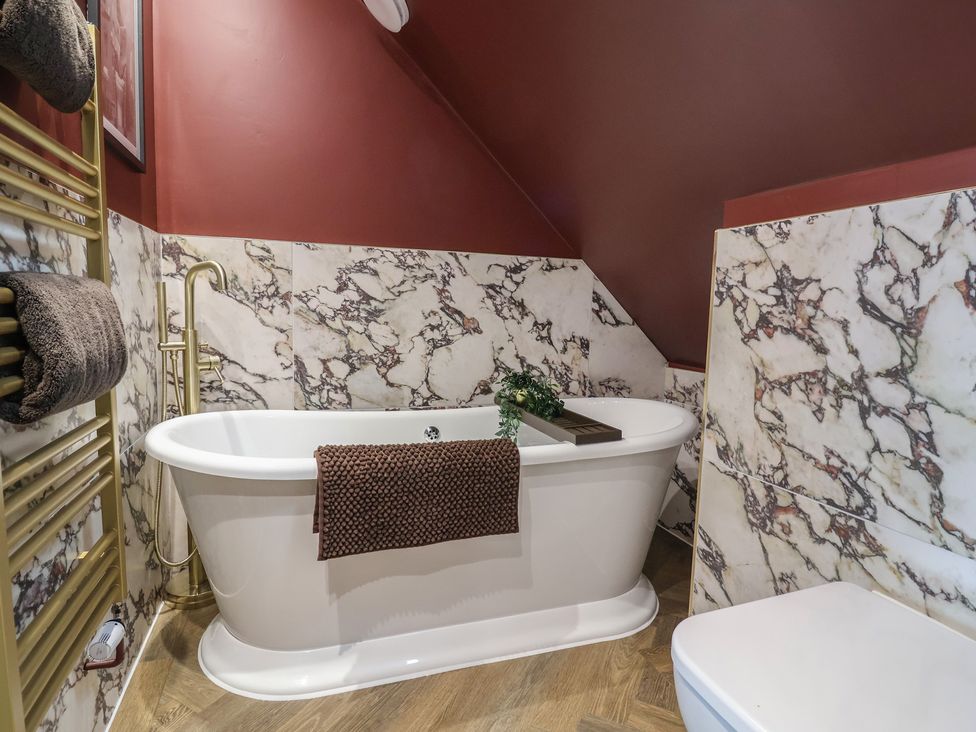 A bathroom with a bathtub and towel radiator at Bella Vista in Deganwy