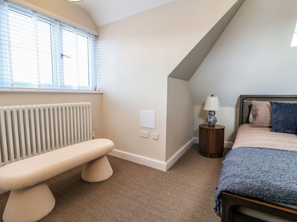 A bedroom with a bed, table, and window at Bella Vista in Deganwy