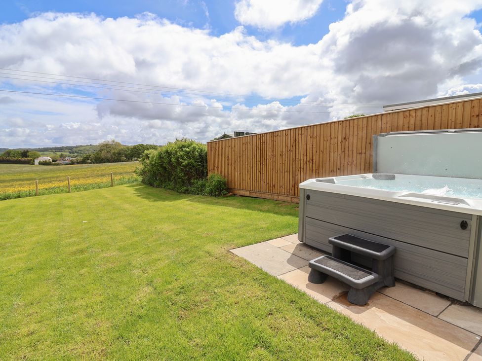 A garden with a hot tub and grass at Bella Vista in Deganwy