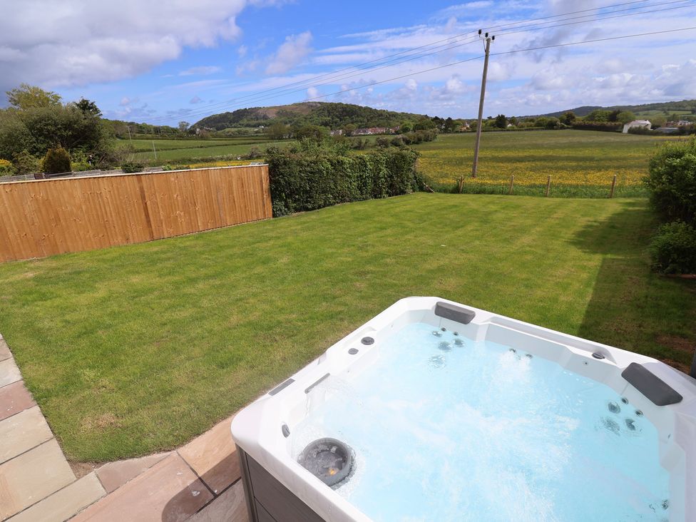 A garden with a hot tub and grass at Bella Vista in Deganwy