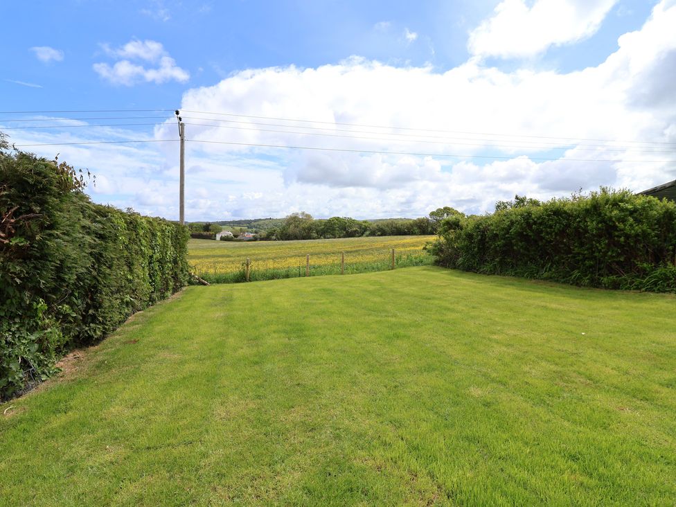 A garden with grass and hedges at Bella Vista in Deganwy