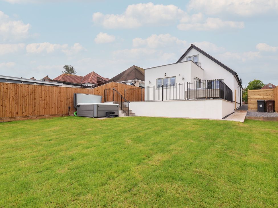 A house with a lawn and hot tub at Bella Vista in Deganwy