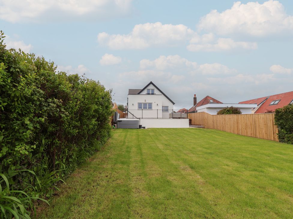 A house with a lawn and fence at Bella Vista in Deganwy