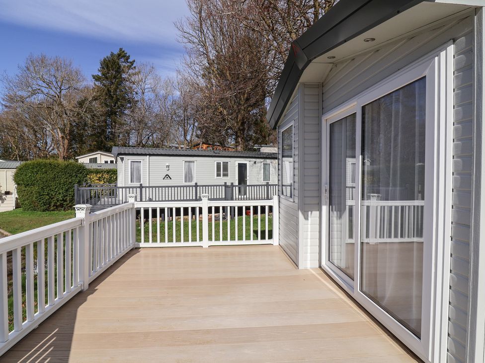 An outdoor deck area with a view of caravans at Woodlands Hall Caravan Park near Ruthin