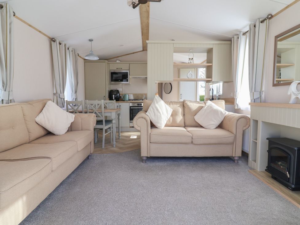 A living room with sofa and dining area at Caravan Woodlands Hall Caravan Park near Ruthin