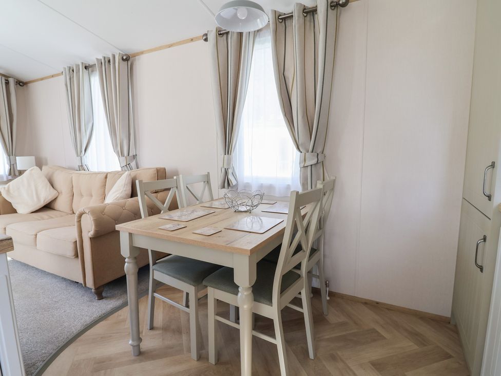 A dining room with a table and chairs at Caravan Woodlands Hall Caravan Park near Ruthin