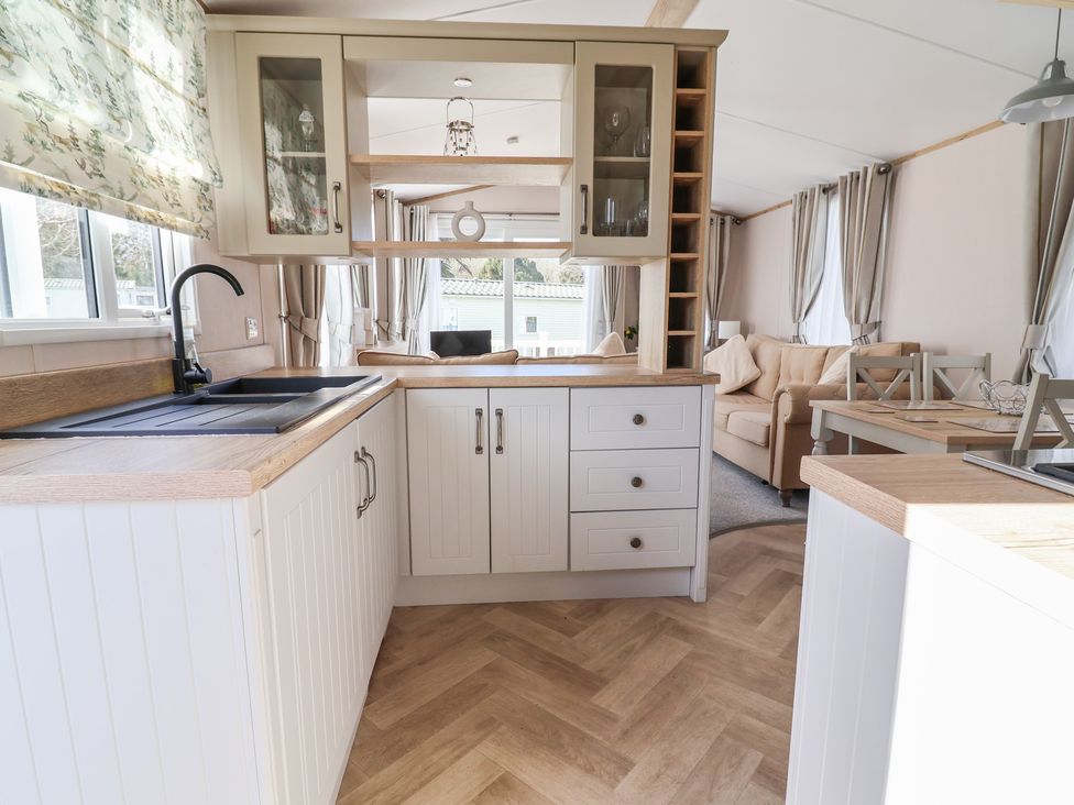A kitchen with a sink and storage cabinets at Caravan, Woodlands Hall Caravan Park near Ruthin