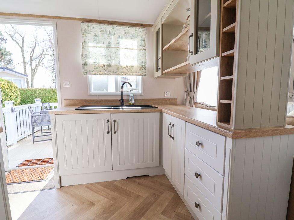 A kitchen with a sink and cabinets at the Caravan in Woodlands Hall Caravan Park near Ruthin