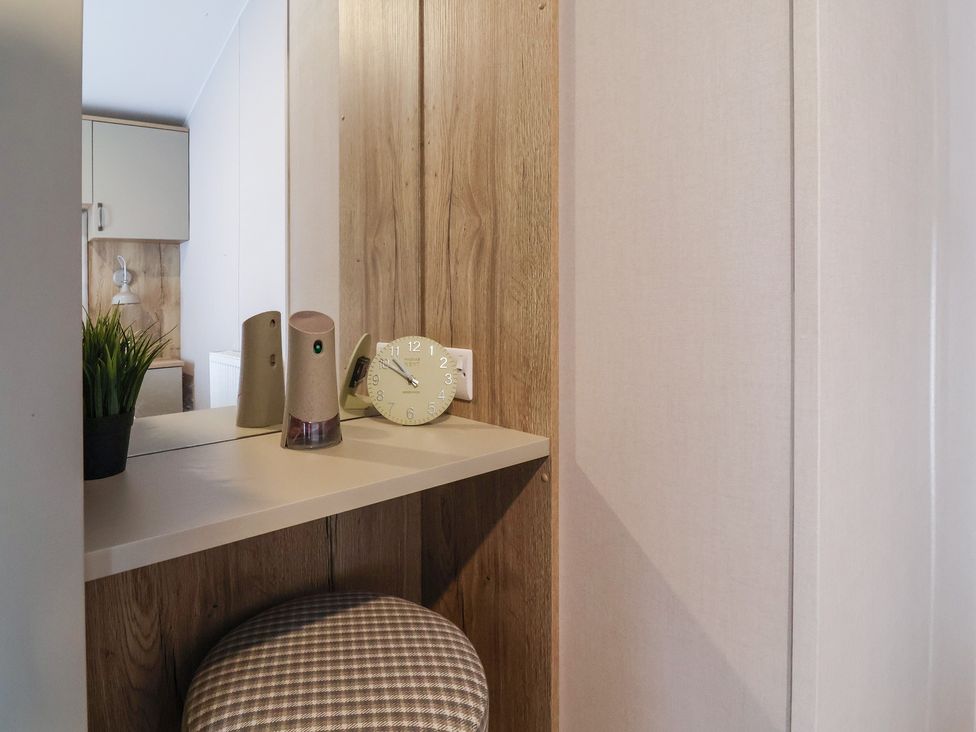 A kitchen with a clock and a plant at Caravan Woodlands Hall Caravan Park near Ruthin