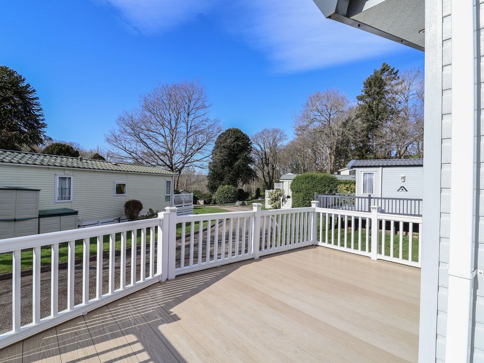 An outdoor area with decking and caravans at Woodlands Hall Caravan Park near Ruthin