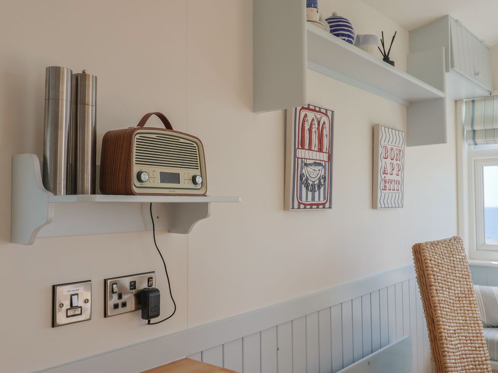 A kitchen with a radio and wall art at Salt & Stone in Lyme Regis