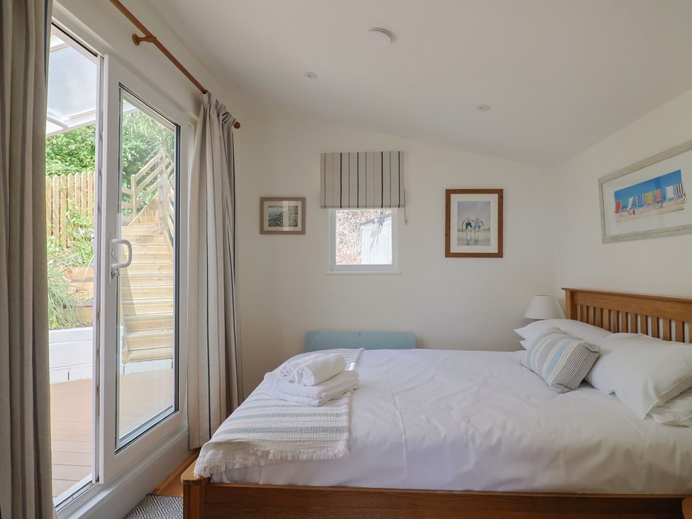 A bedroom with a bed and window at Salt & Stone in Lyme Regis