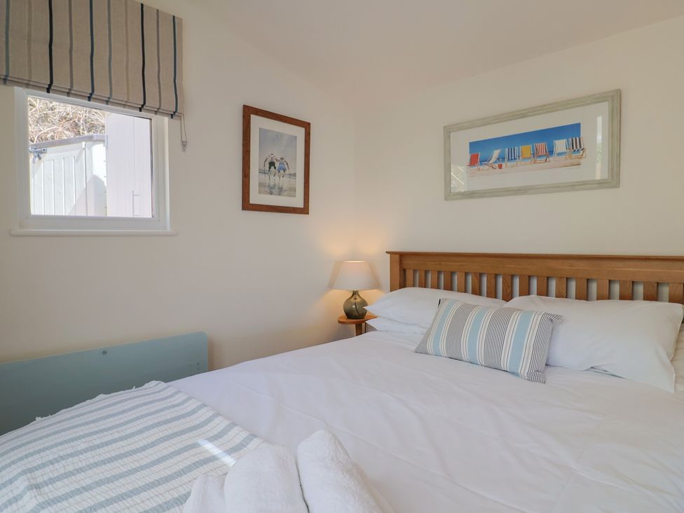 A bedroom with a bed and window at Salt & Stone Lyme Regis
