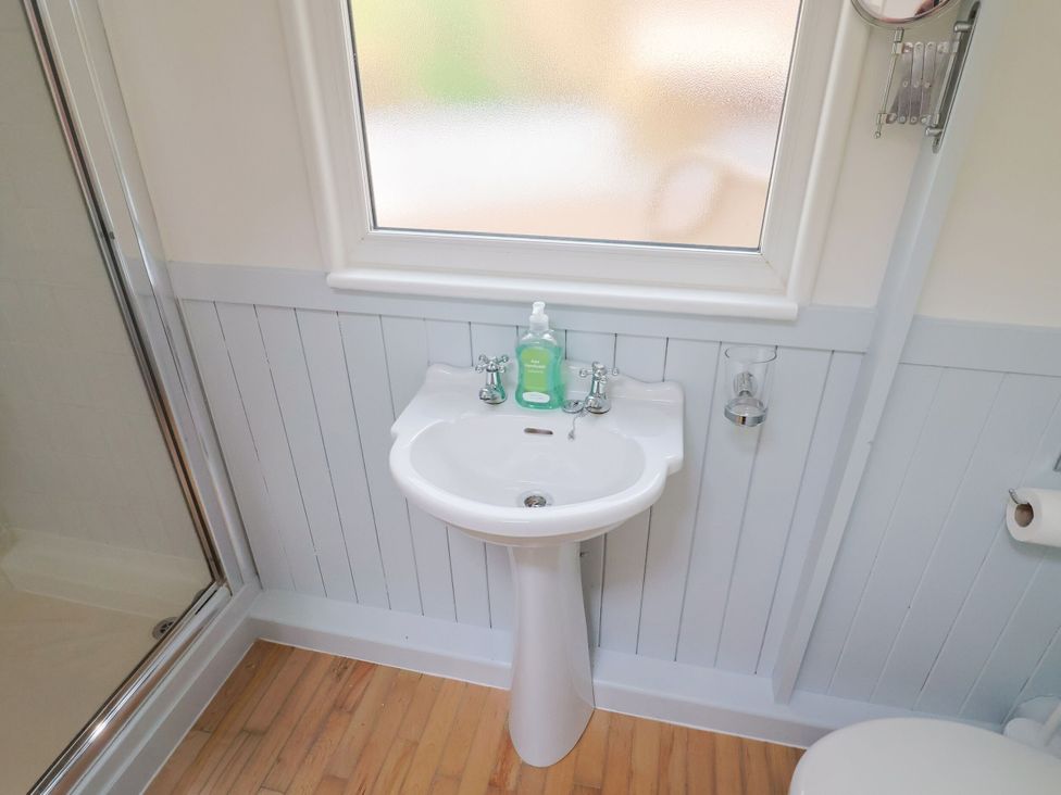 A bathroom with a sink and soap dispenser at Salt & Stone Lyme Regis