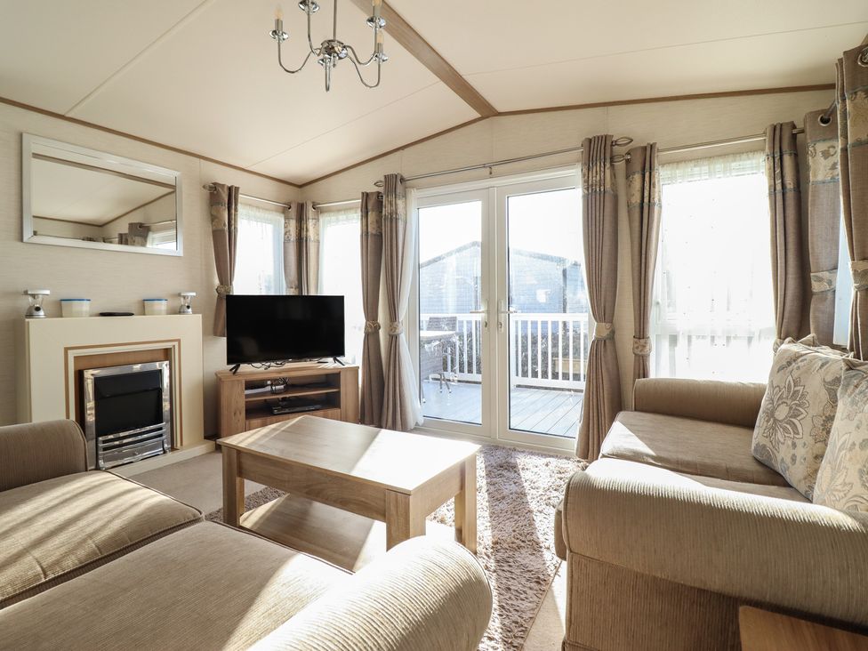 A living room with a television and a coffee table at 23 Gull Court in Porthmadog