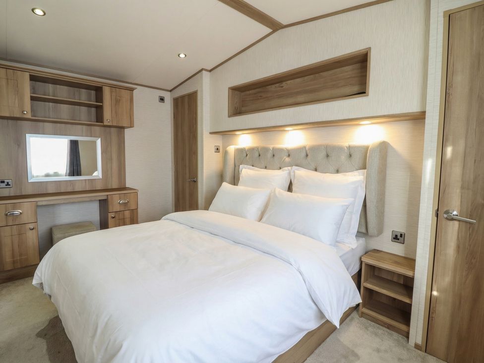 A bedroom with a bed and desk in 23 Gull Court Porthmadog