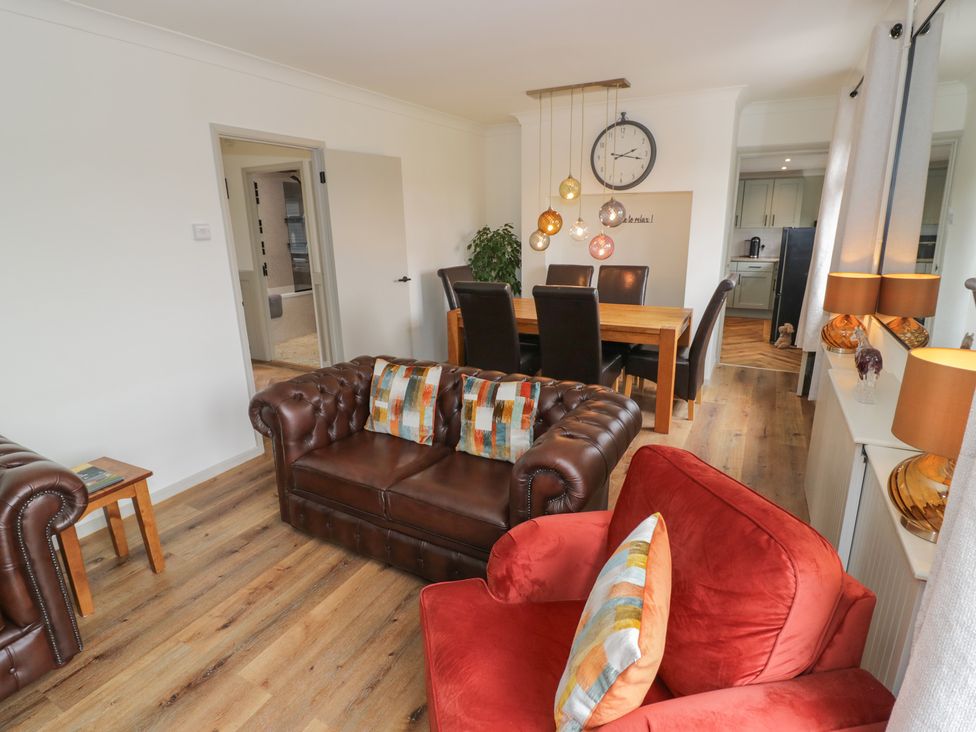 A living room with a sofa, dining table, and light fixture at 3 Swedish House in Walgrave