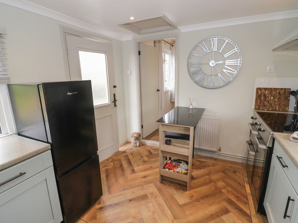 A kitchen with a refrigerator, table, and oven at 3 Swedish House in Walgrave